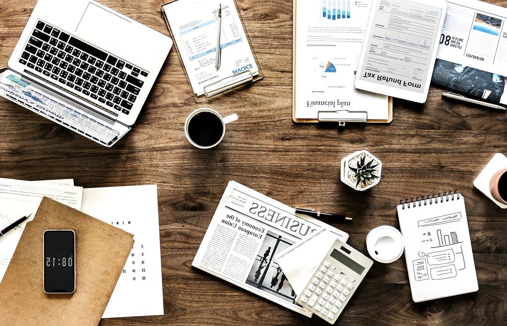 Person using laptop with digital devices around